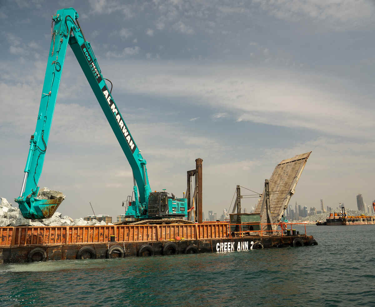 Kobelco SK850 long boom excavator in action for a marine project.