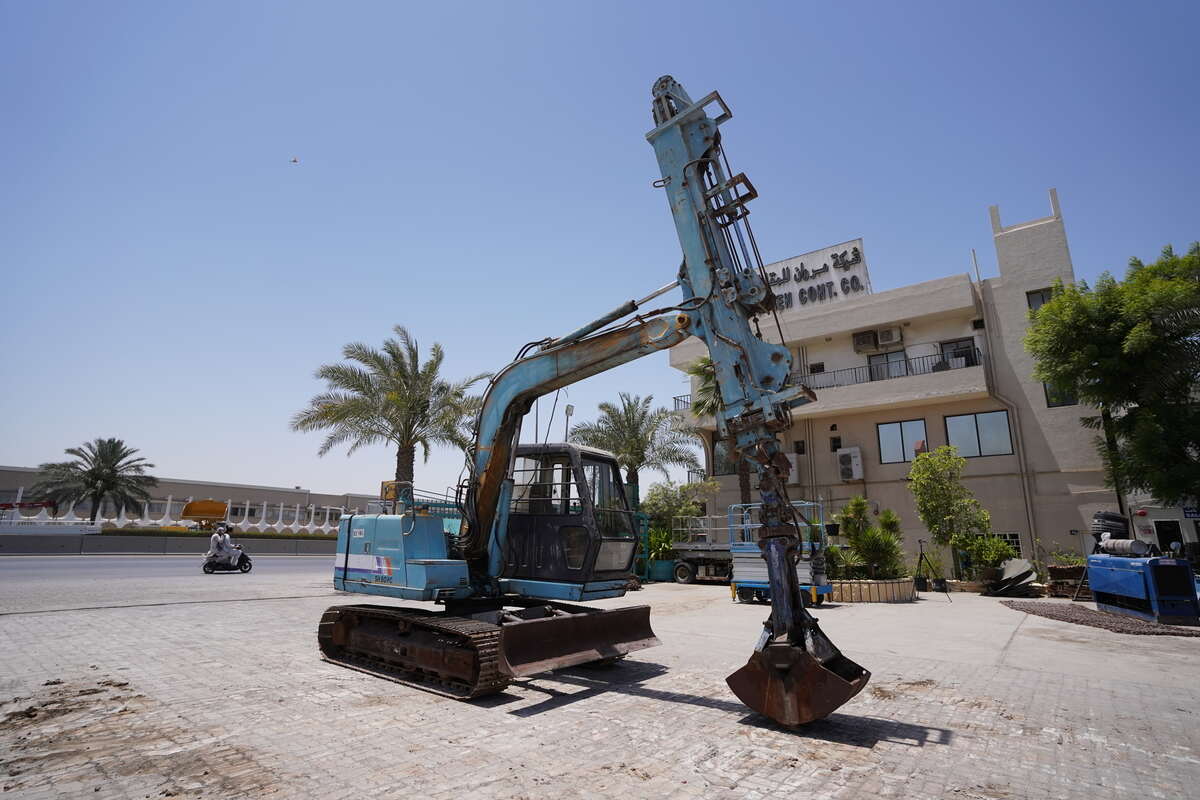 Mini excavator fitted with a telescoping boom and grapple